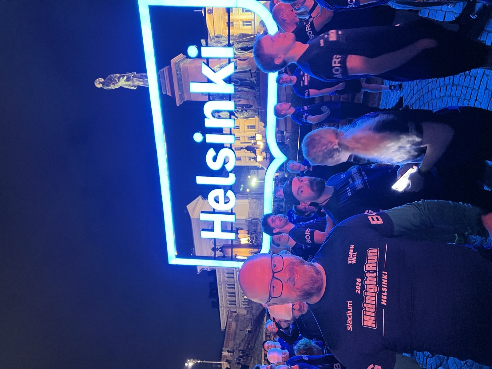 At the start area on Senate Square before the Helsinki Midnight Run 2026 start, with the illuminated Helsinki sign and the statue of Alexander II in the background